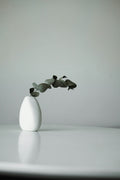 White ceramic vase with greenery